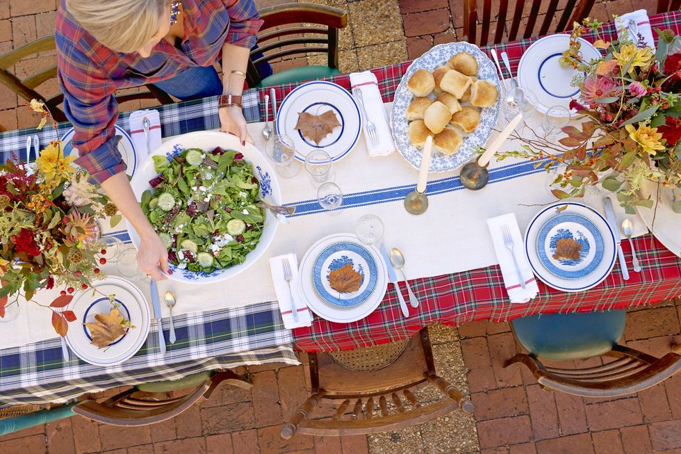 friendsgiving style table being set up outdoors