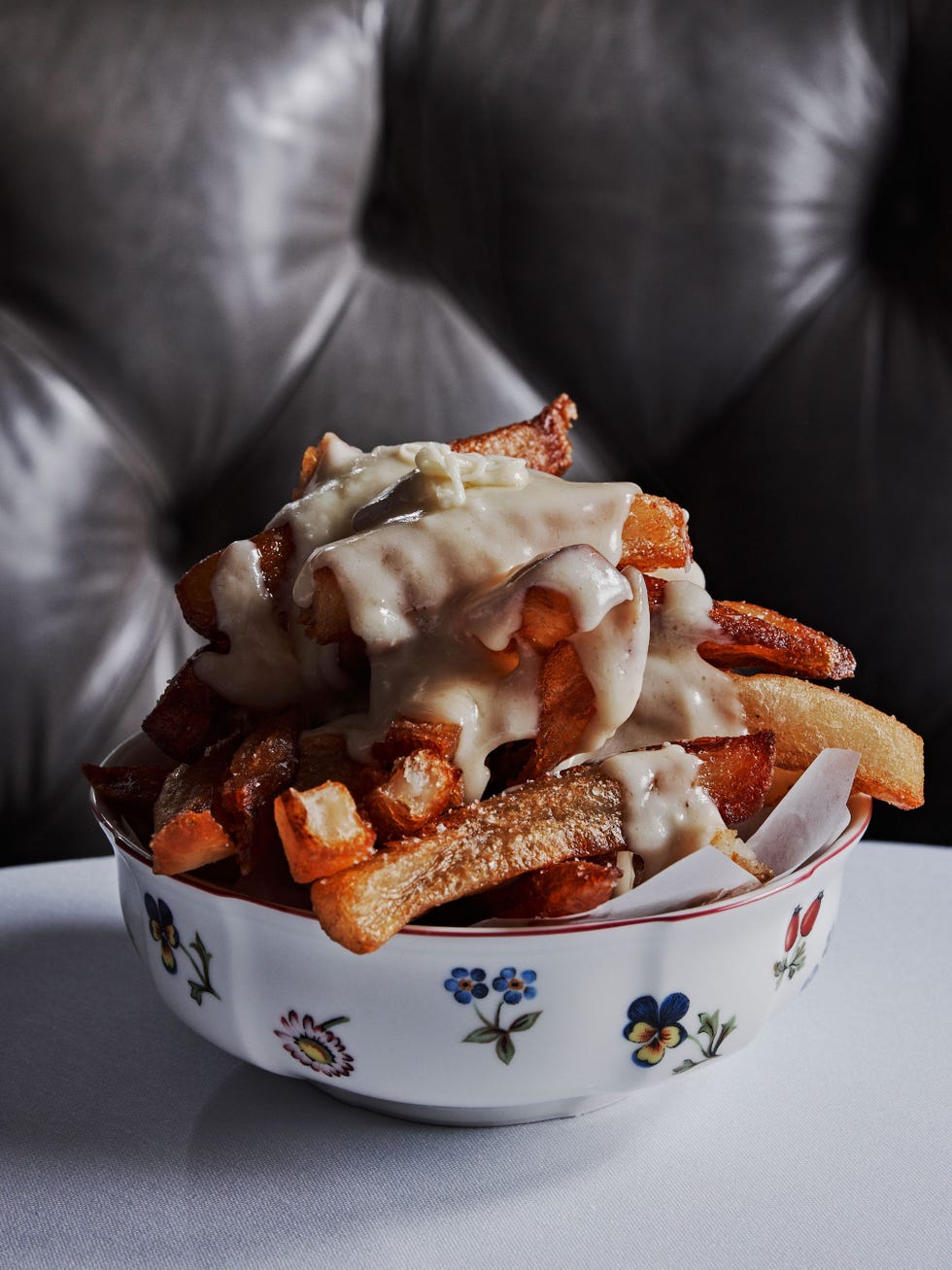 a bowl of fries topped with creamy sauce