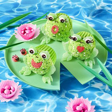 a group of green and pink cupcakes on a blue and white surface