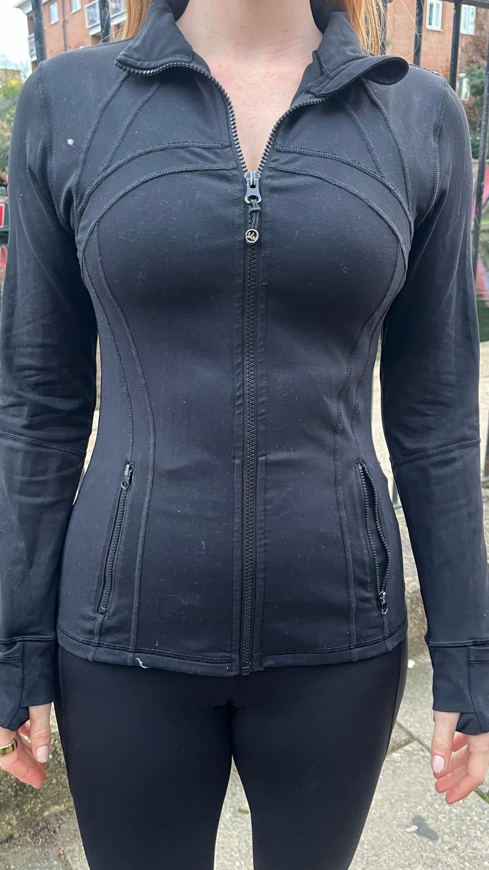 woman wearing a fitted black athletic jacket and leggings