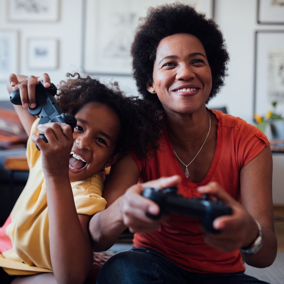 front view of a mother and daughter playing video games together