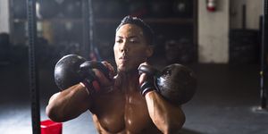 Front view of athlete doing kettle bell squats, San Diego, California, USA