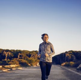 front view of woman running on road against clear sky