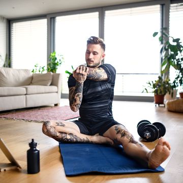 front view portrait of man with tablet doing workout exercise indoors at home