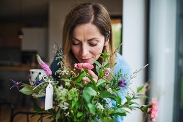 mujer oliendo ramo de flores