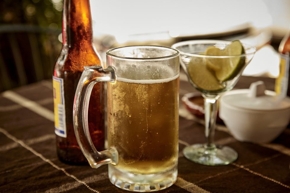a frosty glass of beer on a table outside a mexican bar