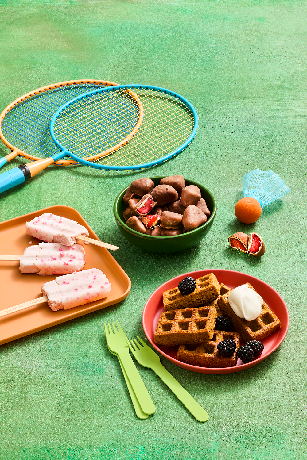 frozen snacks including waffles, ice cream bars and fruit on a green sporty background