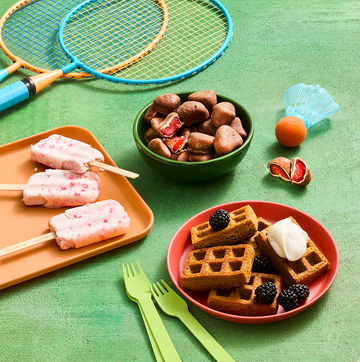Frozen snacks including waffles, ice cream bars and fruit on a green sporty background frozen snacks including waffles, ice cream bars and fruit on a green sporty background