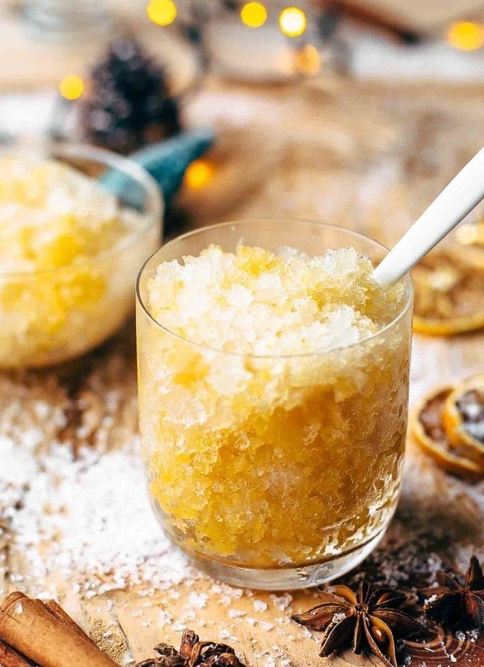 orange bourbon slush in a glass with a spoon