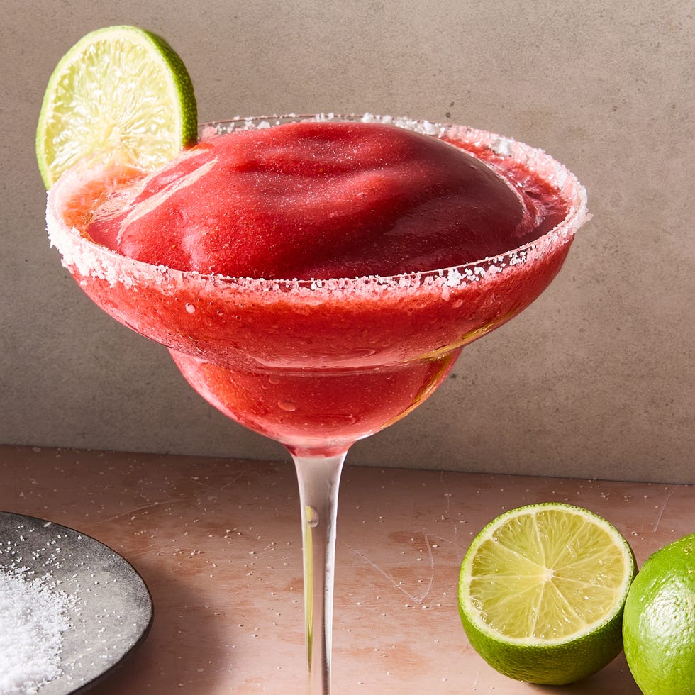 frozen strawberry margarita in glass with a salt rim and lime garnish