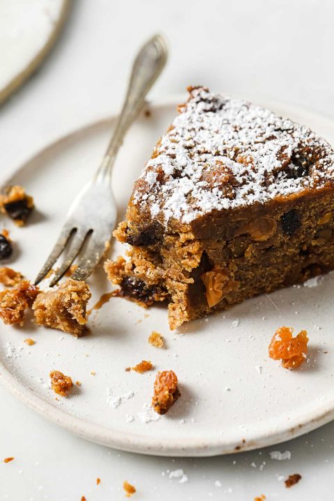 gluten free fruit cake slice on plate with powdered sugar