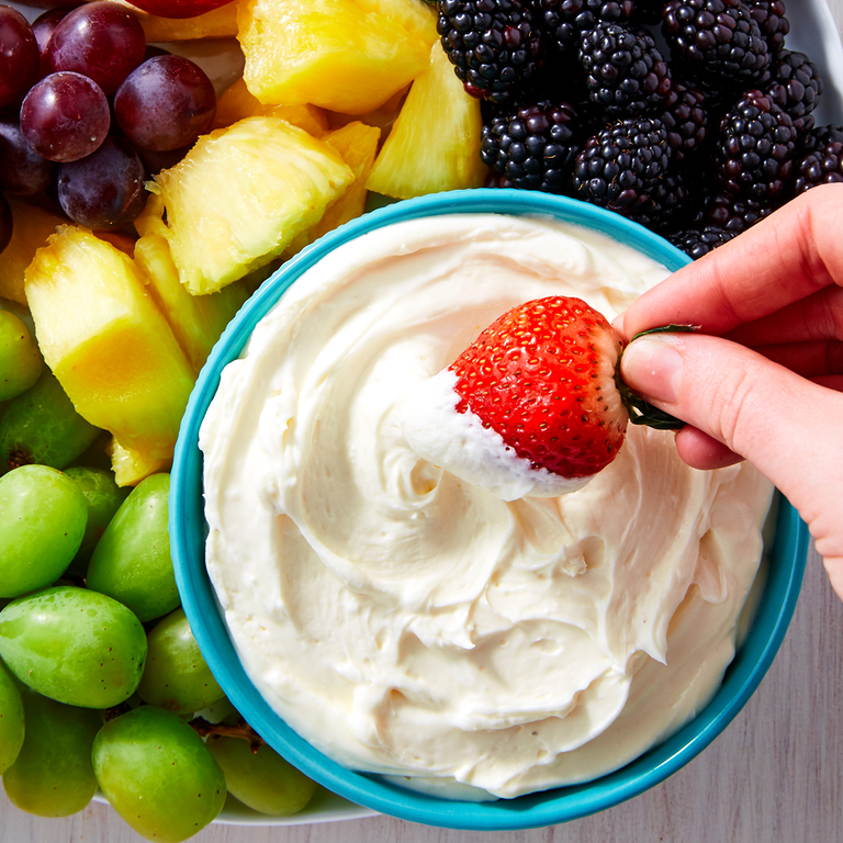 marshmallow dip in a blue bowl surrounded by fruit