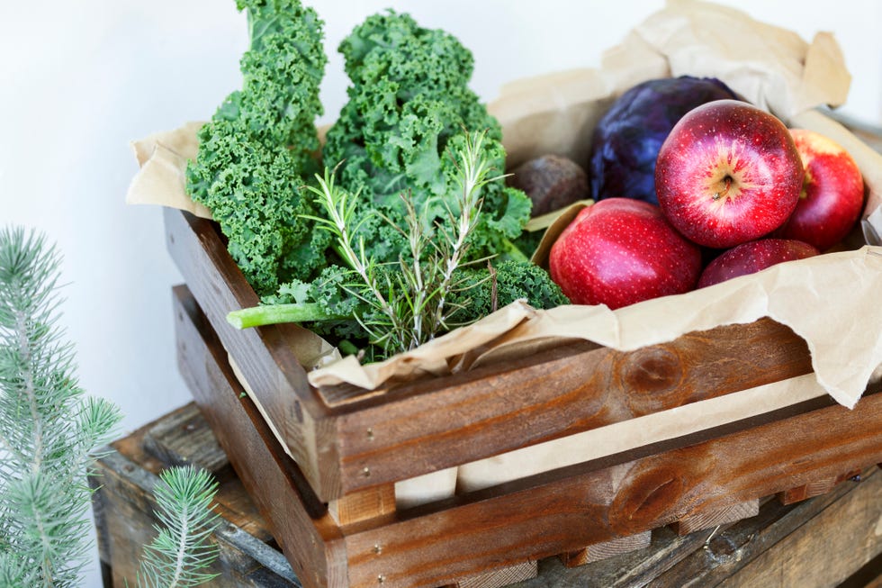 Cajón de frutas y vegetales, entre ellos kale y manzana