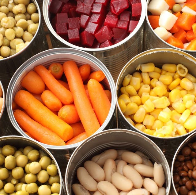 varias latas con diferentes frutas, verduras y alubias