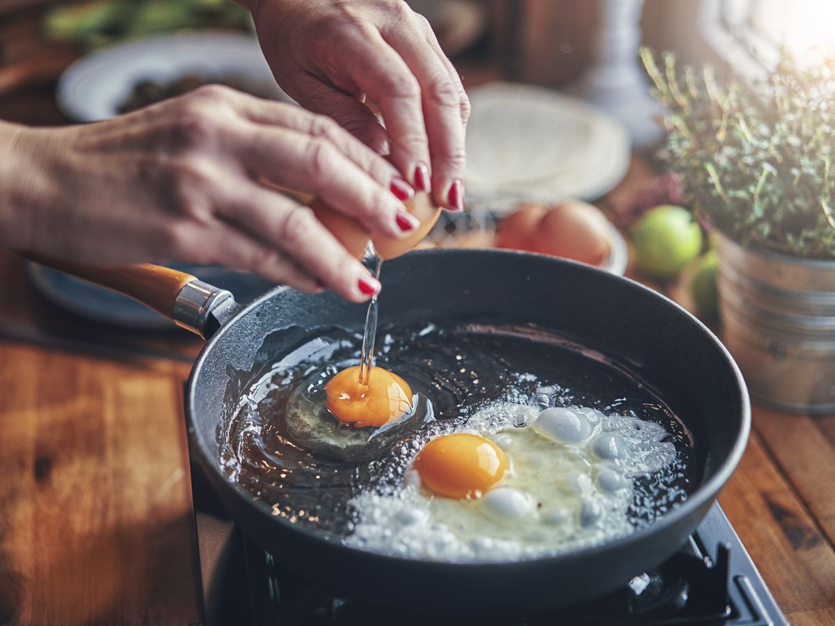 https://hips.hearstapps.com/hmg-prod/images/frying-egg-in-a-cooking-pan-in-domestic-kitchen-royalty-free-image-1129381764-1566925040.jpg?crop=0.88931xw:1xh;center,top&resize=1200:*