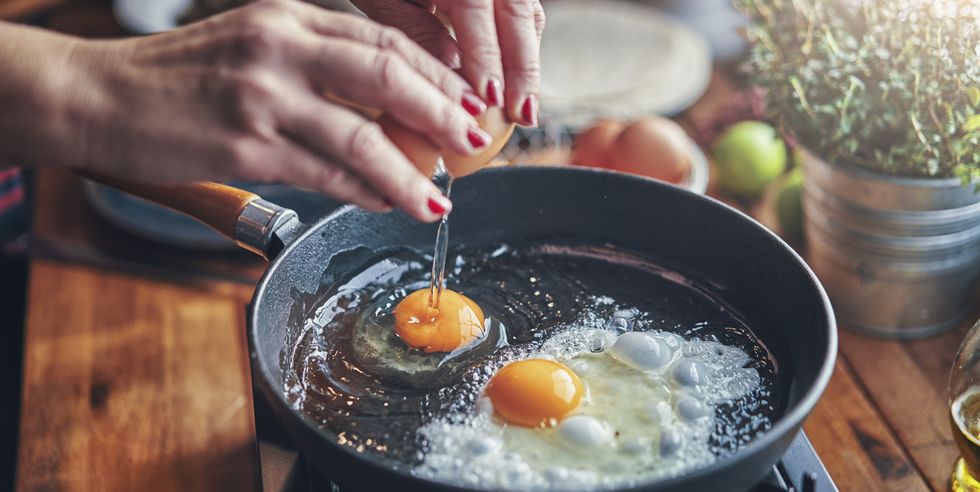 frying egg in a cooking pan in domestic kitchen