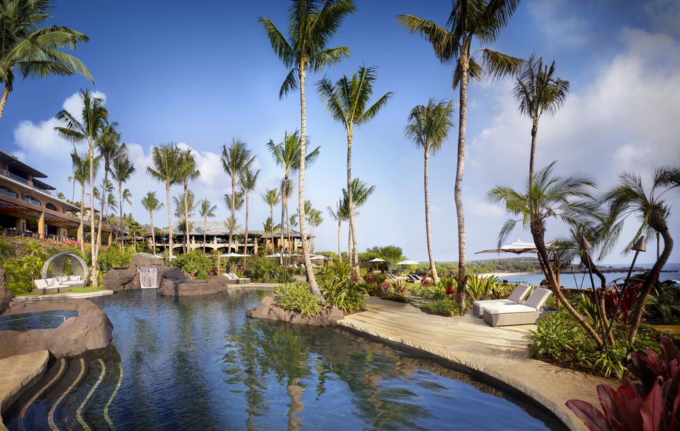 the pool and palm trees at four seasons lanai in hawaii