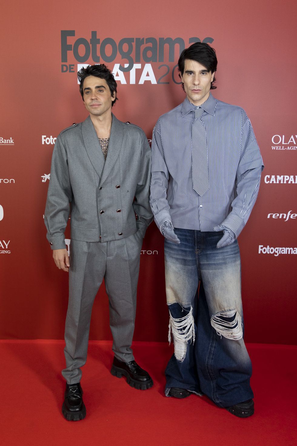 two men standing on a red carpet