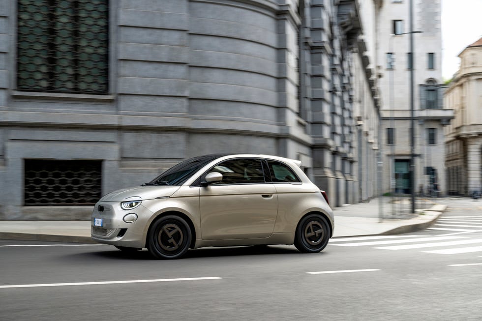 A beige two-door Fiat zooming around the streets