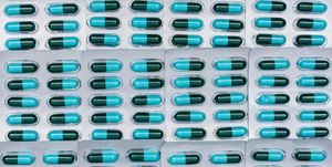 full frame of blue and green antibiotics capsule pills in blister packs antimicrobial drug