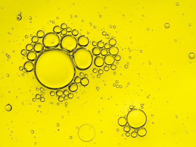 Full Frame of circular bubbles floating on water yellow