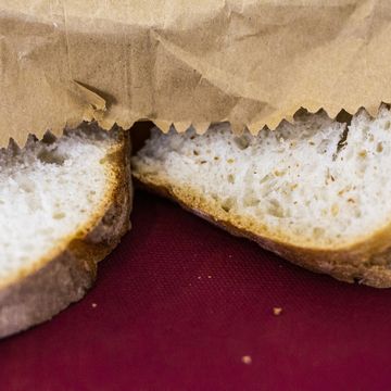full frame shot of sliced apulian bread contained in a paper bag with red background, italy