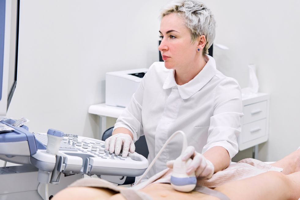 una doctora hace una ecografía abdominal a una mujer