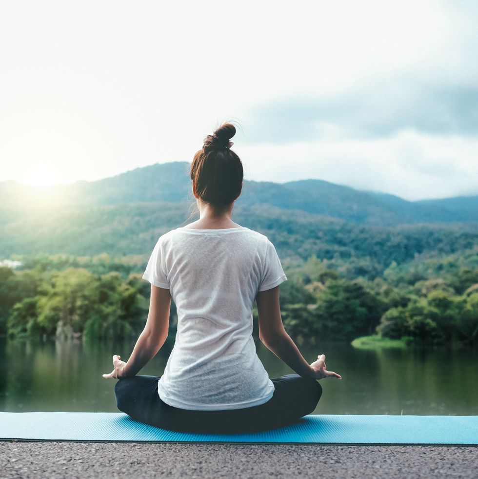 Full Length Of Woman Doing Yoga Against Lake