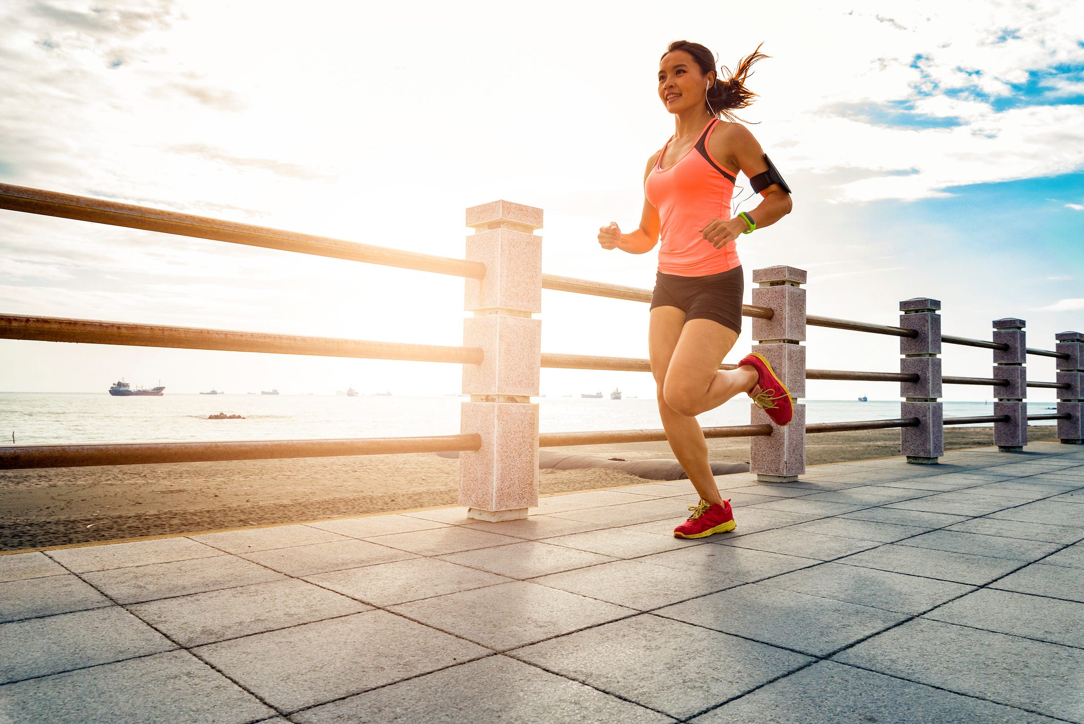 Full Length Of Woman Running On Footpath By Railing