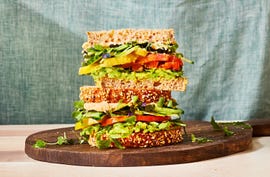 veggie sandwich with avocado, tomato, cucumber, and greens