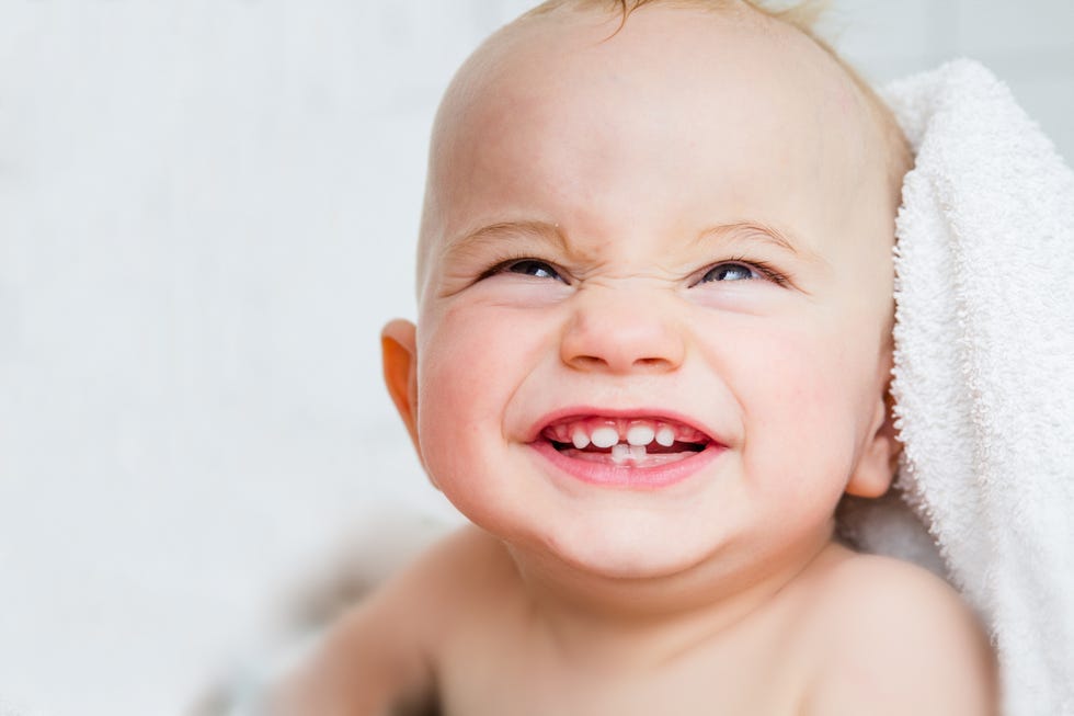bebé mostrando sus primeros dientes de leche