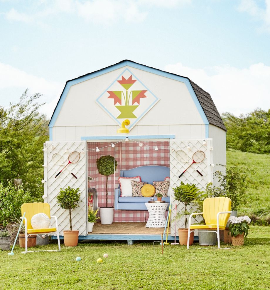 backyard shed decorated with wallpaper, a hanging swing, and outdoor furniture