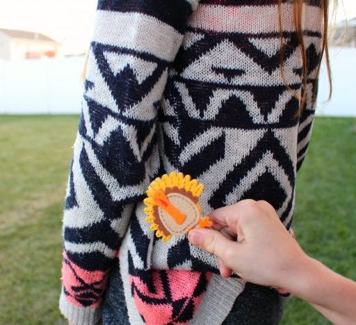 a felt turkey on a black and white patterned sweater