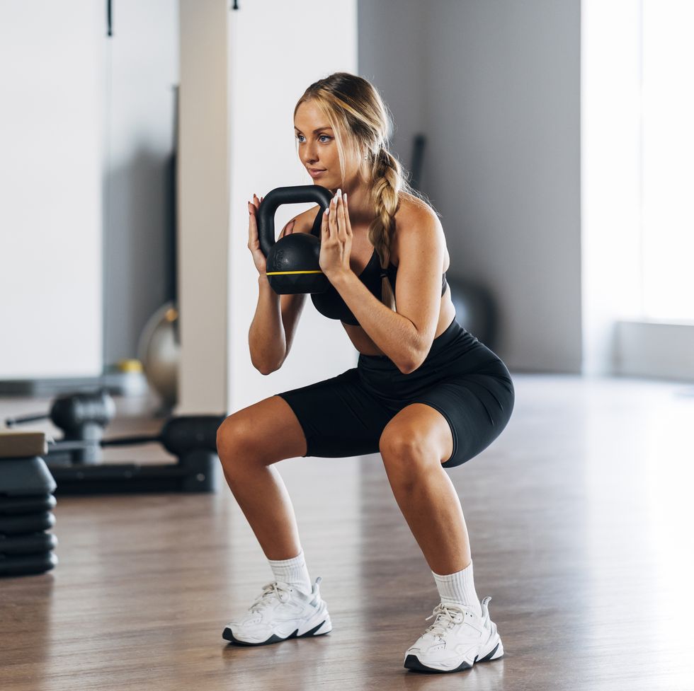 woman doing squat with kettle bell