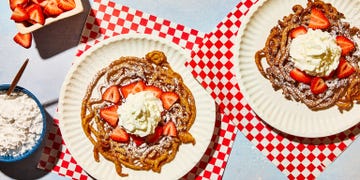 funnel cake topped with strawberries and powdered sugar