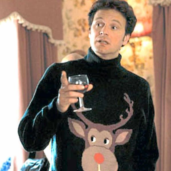 mark darcy holds a glass of wine while wearing a tacky rudolph sweater in a scene from bridget jones's diary
