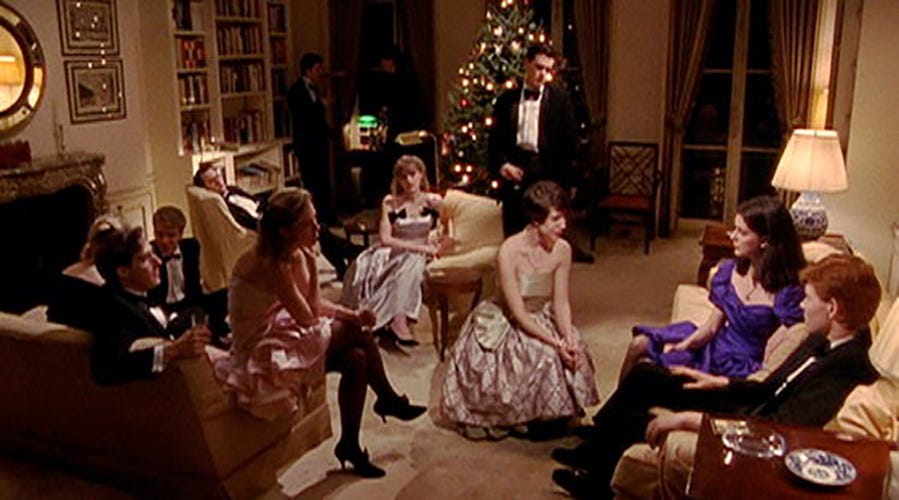 a group of dressed up young people gather in a fancy city apartment that's decorated for the holidays in a scene from metropolitan