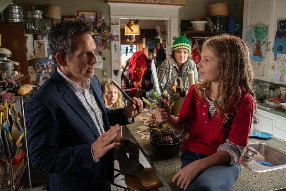 mike talks to junior, with his brothers behind him, in a messy kitchen in a scene from nutcrackers