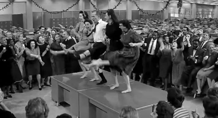 a group of people dance during a raucous christmas party in a scene from the apartment