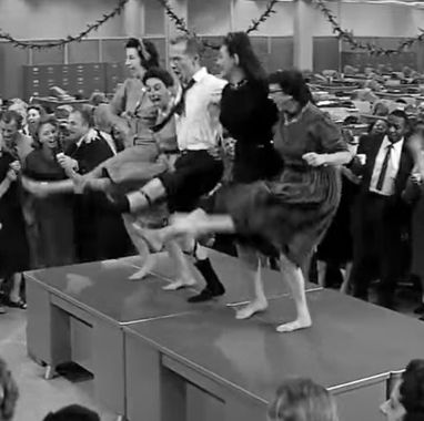 a group of people dance during a raucous christmas party in a scene from the apartment