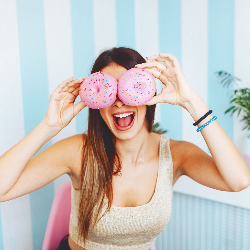 Funny girl  holding donut near eyes