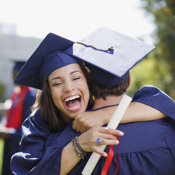 smiling graduates hugging outdoors