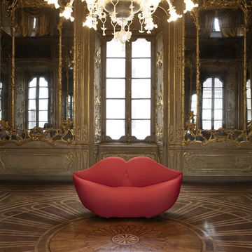 a red leather chair in a room with large windows
