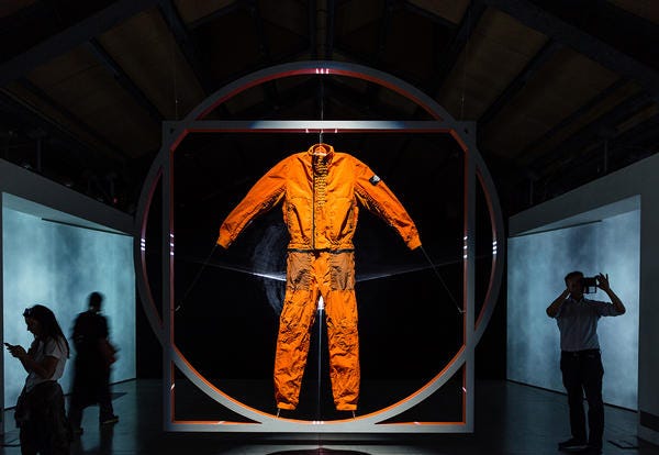 Orange, Design, Outerwear, Space, Fictional character, Art, Theatrical property, Symmetry, 
