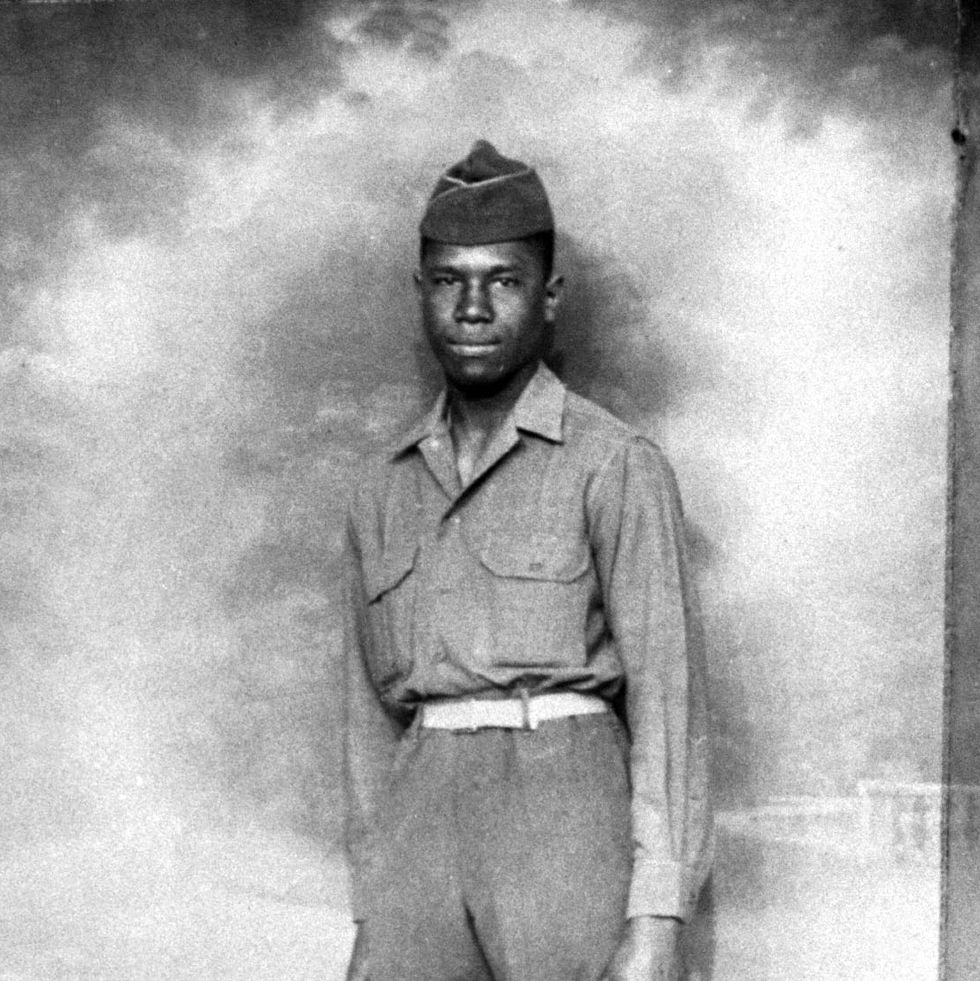 medgar evers standing in front of a backdrop in his military uniform