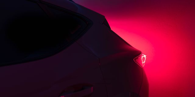 futuristic car with red tail light illuminated in the dark night