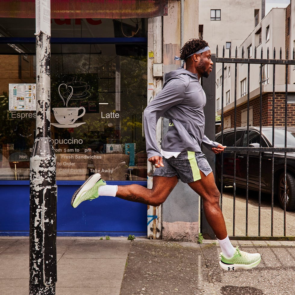 ragazzo che corre in strada con scarpe ua infinite elite verdi