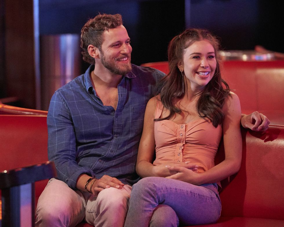 gabby and erich from the bachelorette cuddling on a red couch