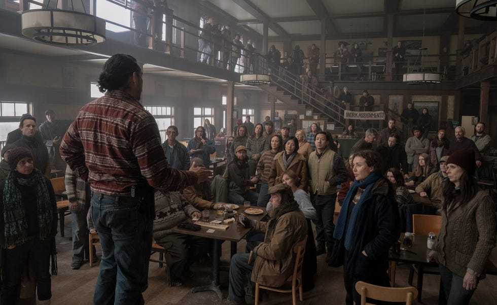a crowd gathered in a social setting engaged in a discussion led by a speaker