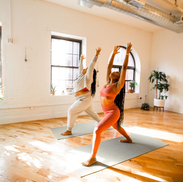 2 black women doing a yoga pose in a yoga studio